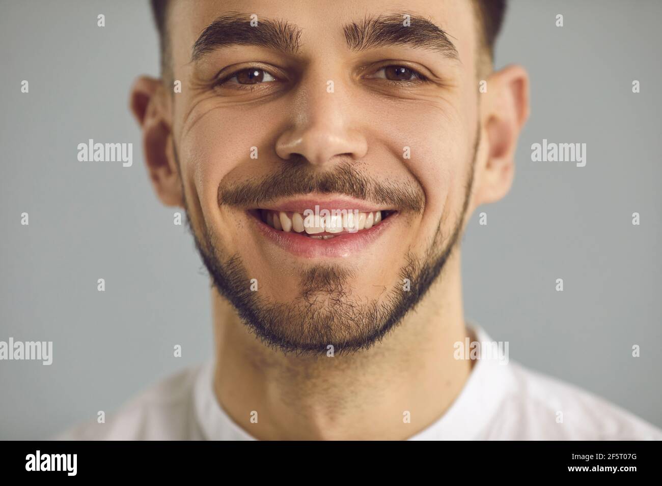 Closeup studio portrait of a happy young Caucasian man with a friendly open smile Stock Photo