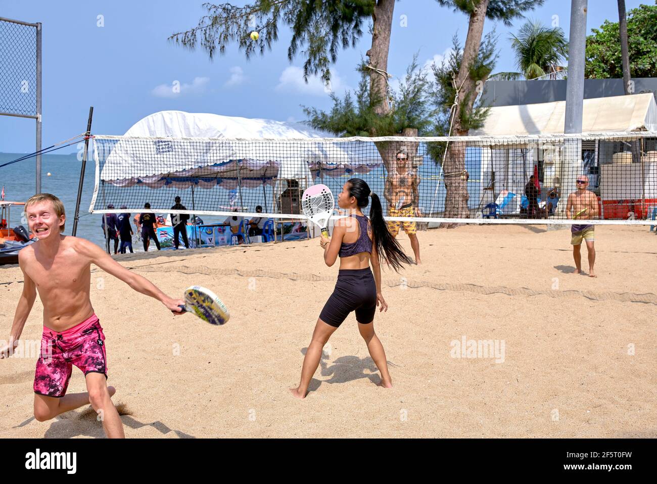 Beach tennis and players facial expression following a successful back hand return of the ball. Stock Photo