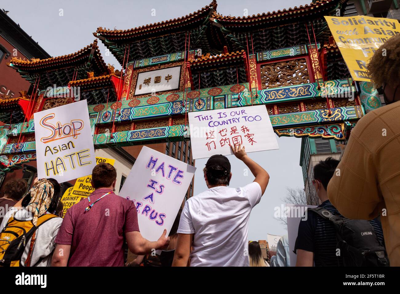 Washington, DC, USA, 27 March, 2021.  Pictured: Protesters hold a variety of signs at the Chinatown Gate for the National Day of Action to Stop Anti-Asian Violence, hosted by ANSWER Coalition.  Credit: Allison C Bailey/Alamy Live News Stock Photo