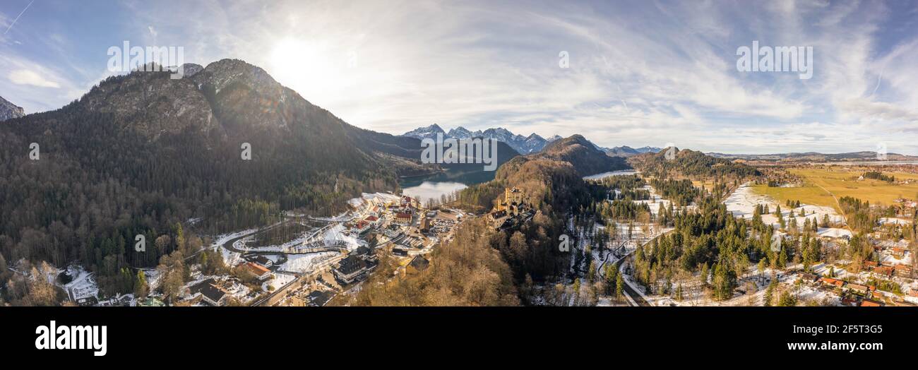 Aerial panorama drone shot of Hohenschwangau by lake in Fussen with view of Alps snow mountain range in Germany winter Stock Photo