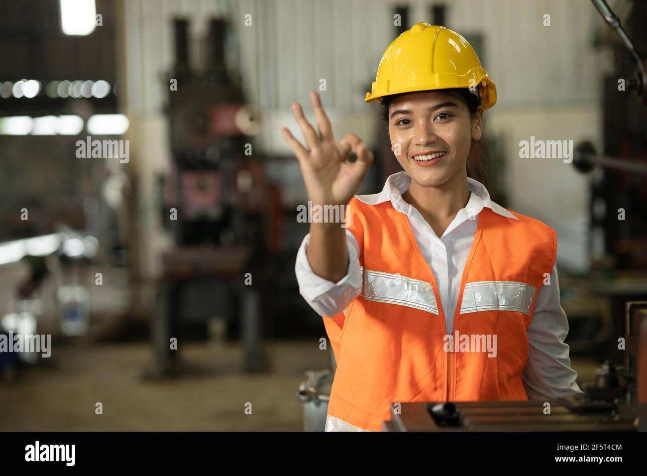 Asian women worker hand showing OK or Good job done no problem sign in