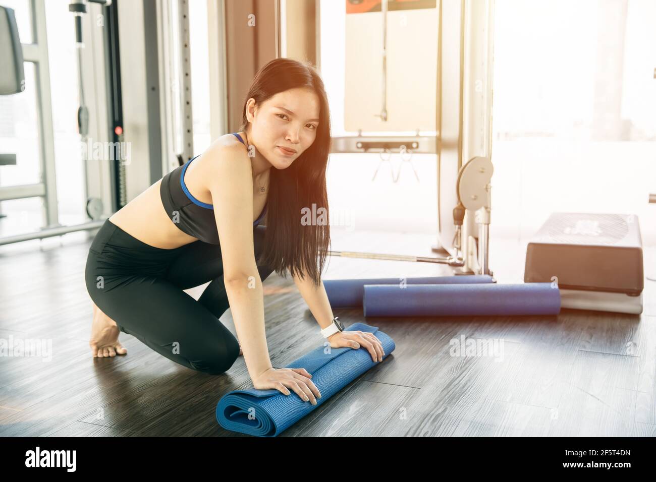 Portrait Sliming Asian women with Yoga mat workout in sport club happy smiling, Healthy lifestyle. Stock Photo