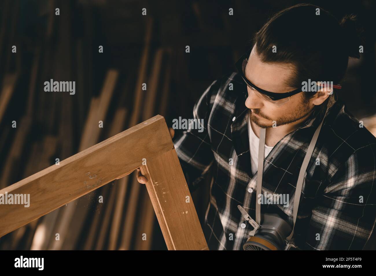 Carpenter man professional skilled in wood work looking detail of masterpiece woodcraft in furniture workshop Stock Photo