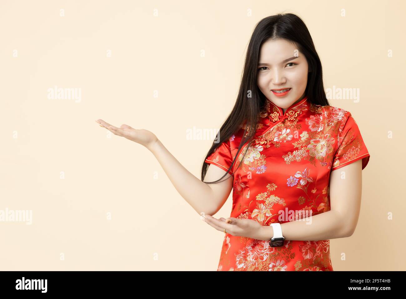Asian Chinese teen girl hand show display presentation sale promotion posture dressing Qipao traditional cloth. Stock Photo