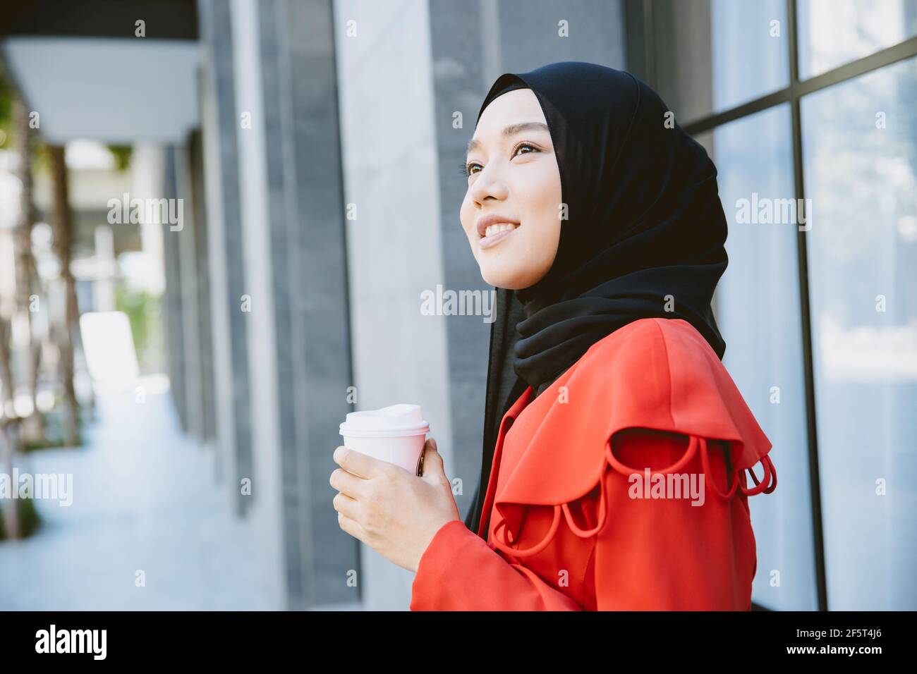 Arab Muslim Asian businesswoman young girl smiling hand hold coffee cup standing portrait Stock Photo