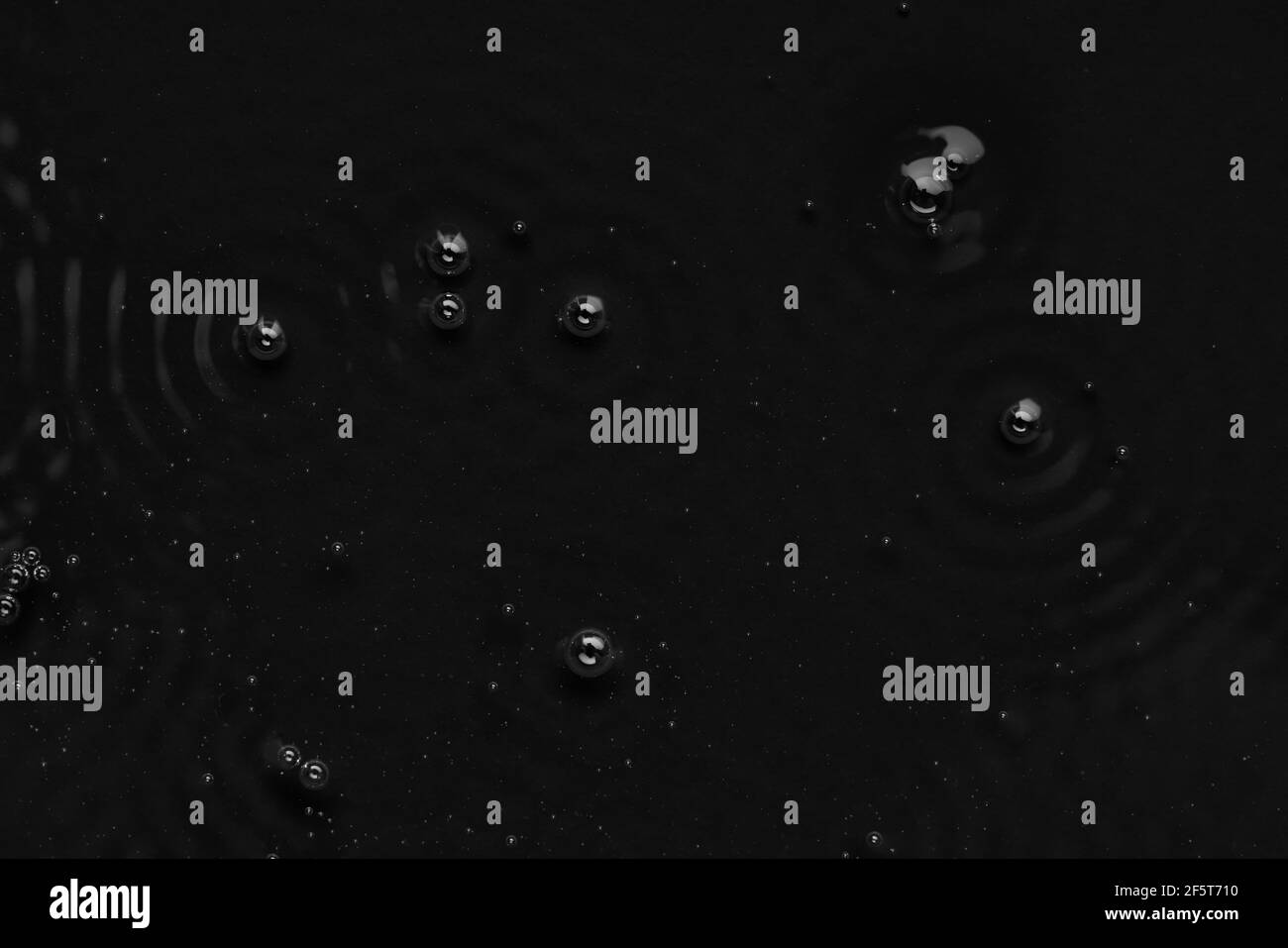 Bubbles on the surface of the liquid. Abstract Black Background Liquid ...