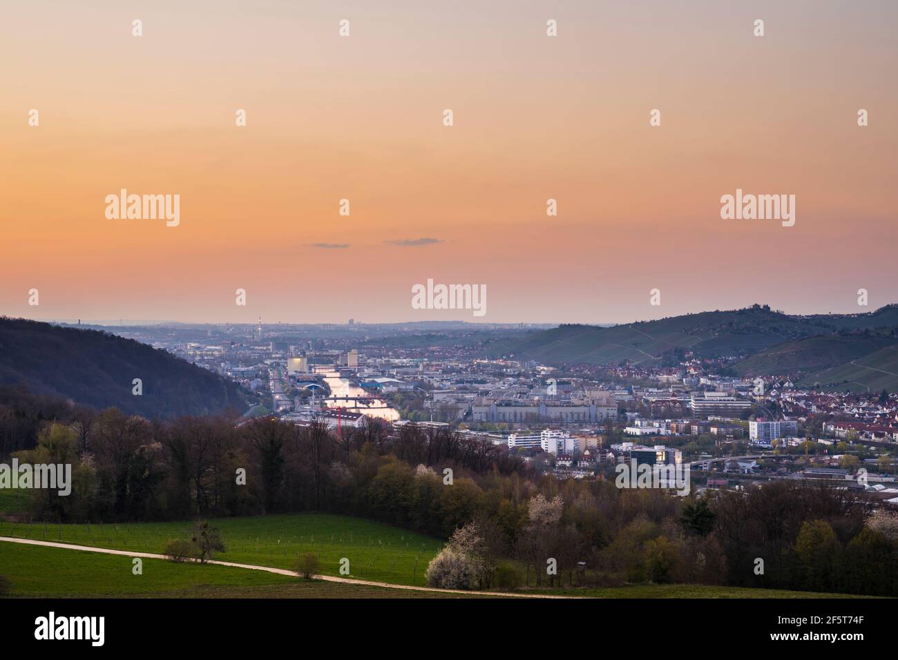 Germany, Orange glowing sunset sky above the houses and neckar river of ...