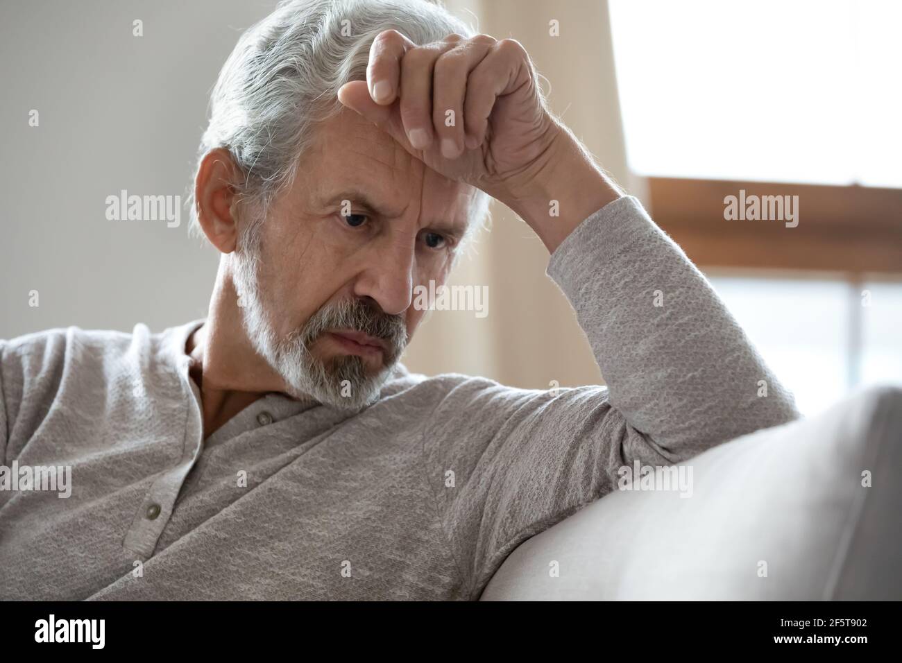 Upset senior man look in distance feeling depressed Stock Photo