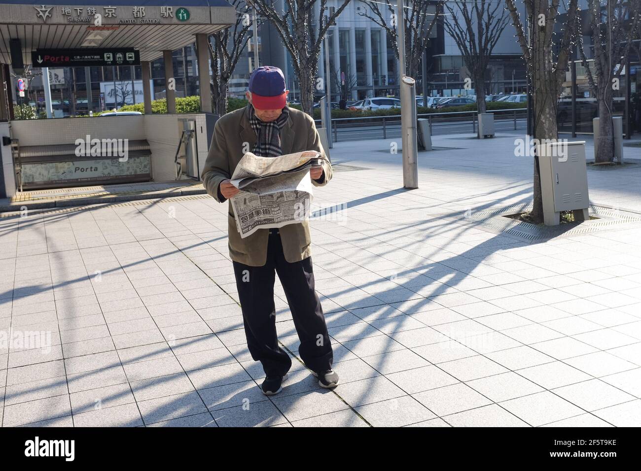 A man reading a newspaper on a street in Kyoto, Japan. Stock Photo