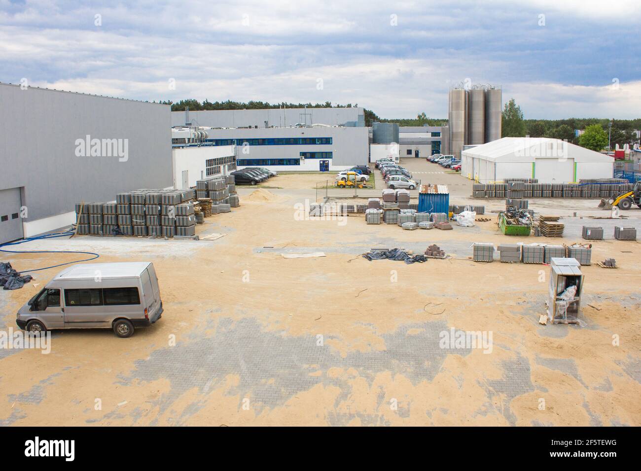 Production workshops and construction work. Workflow scene in industrial yard. Laying paving slabs pavers workers. Building business Stock Photo