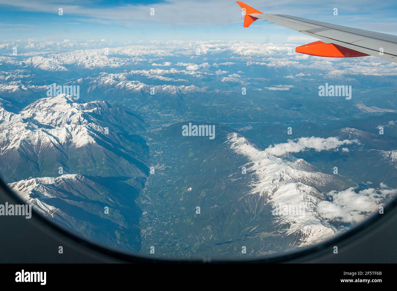 View of Ulten-Ultimo Valley and city of Bolzano in background from an airliner porthole. Concept: air travel, aerial panoramas. Frame given by the air Stock Photo
