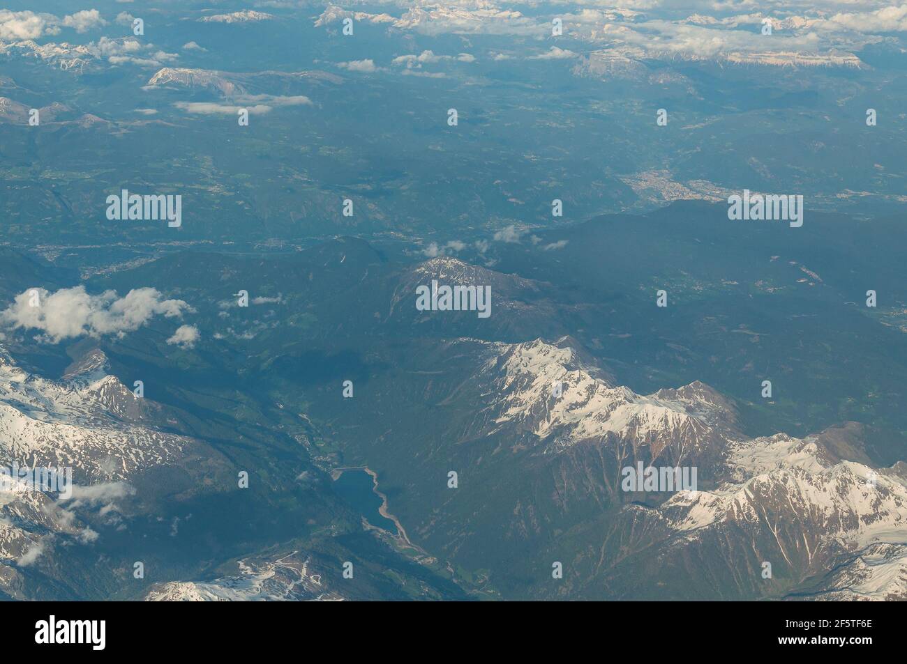 View of Ulten-Ultimo Valley and city of Bolzano in background from an airliner porthole. Concept: air travel, aerial panoramas. Stock Photo