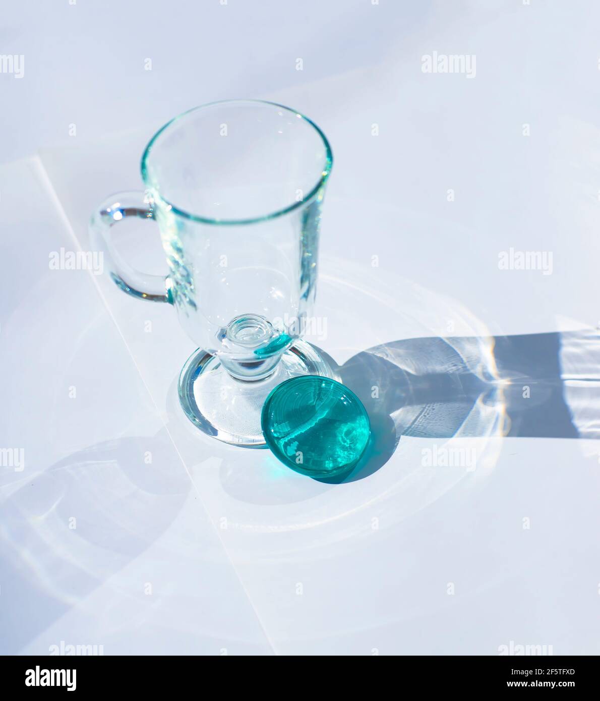 Glass tumbler. Round glass turquoise medallion. Transparent patterned