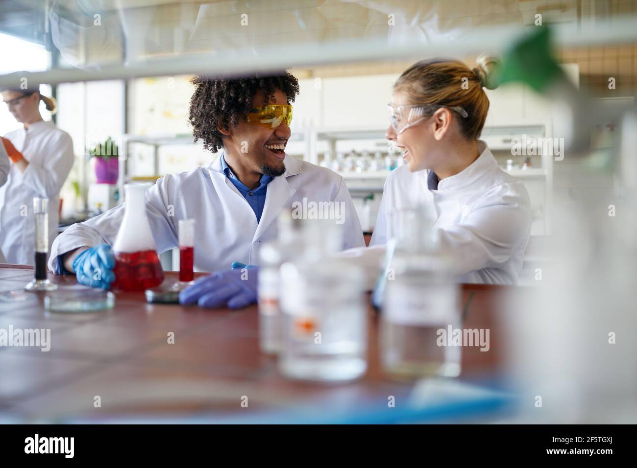 Young scientists enjoy while work in the sterile laboratory environment. Science, chemistry, lab, people Stock Photo