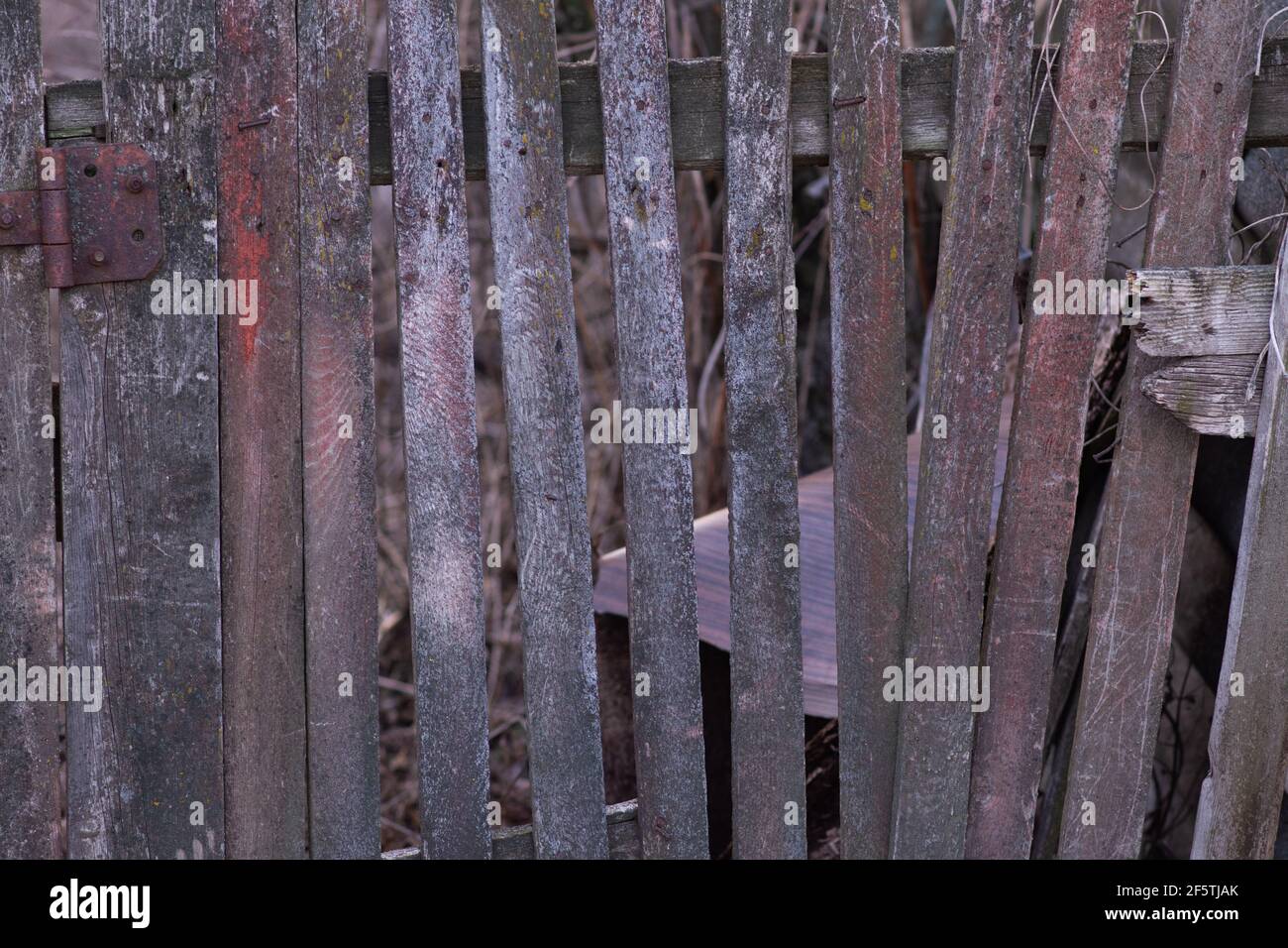 An old wooden fence, leaning from time to time, Stock Photo