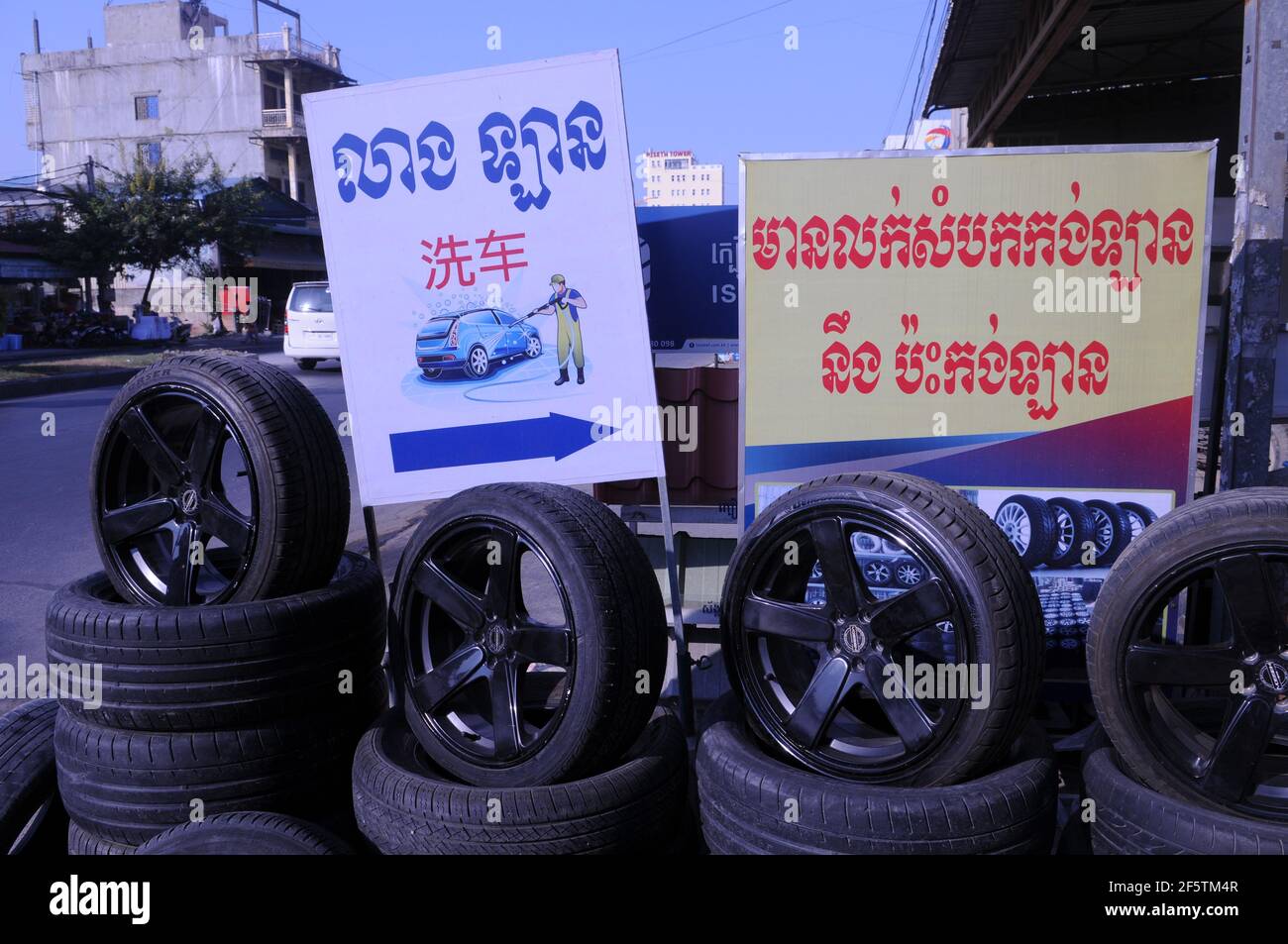 The entrance of a tire shop advertising a car wash w/ a bilingual sign