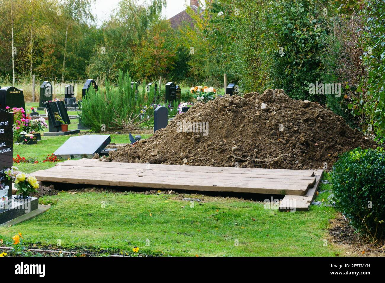Newly dug grave in preparation for a funeral in a typical cemetery in the UK Stock Photo