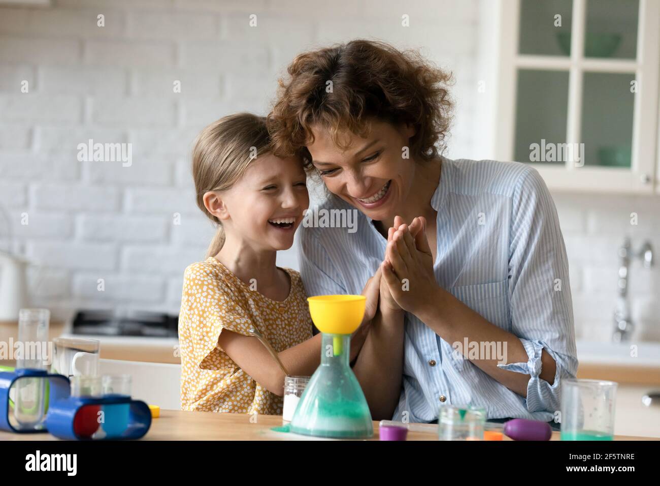 Smiling mom and little daughter play chemistry lab game Stock Photo