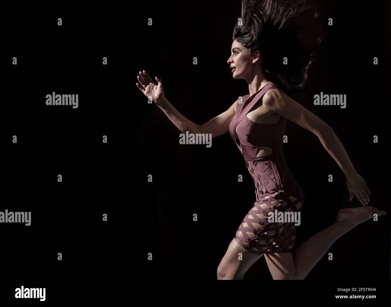 Conceptual photo of an elegant woman running in shade Stock Photo