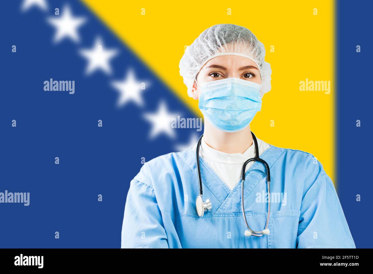 Portrait of a caucasian doctor with flag of Bosnia Herzegovina in background, COVID-19 virus disease crisis, Coronavirus global worldwide pandemic, so Stock Photo