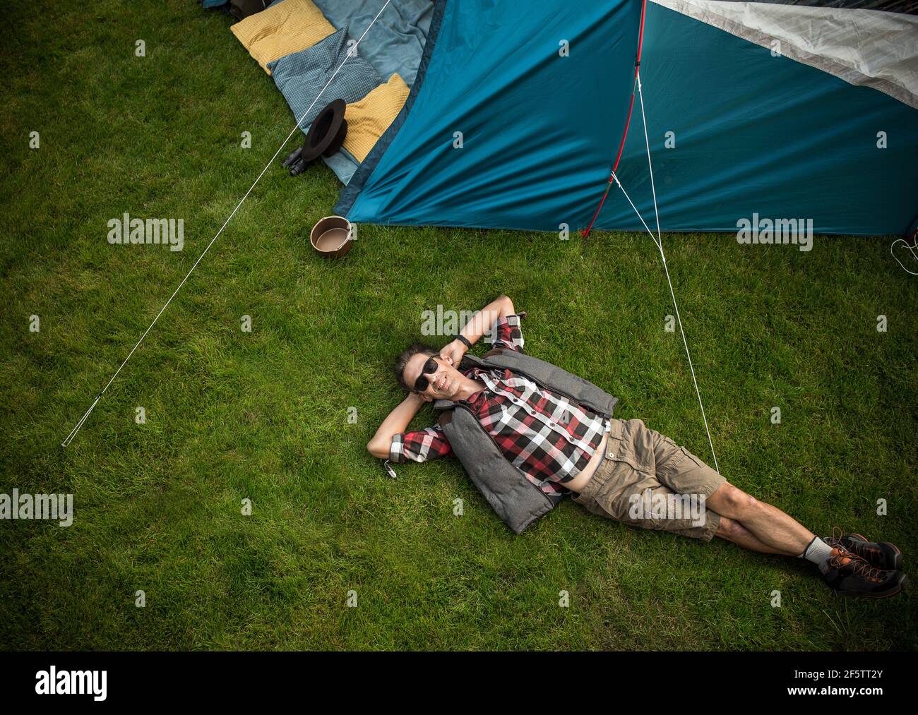Relaxed guy resting on a fresh, green lawn Stock Photo