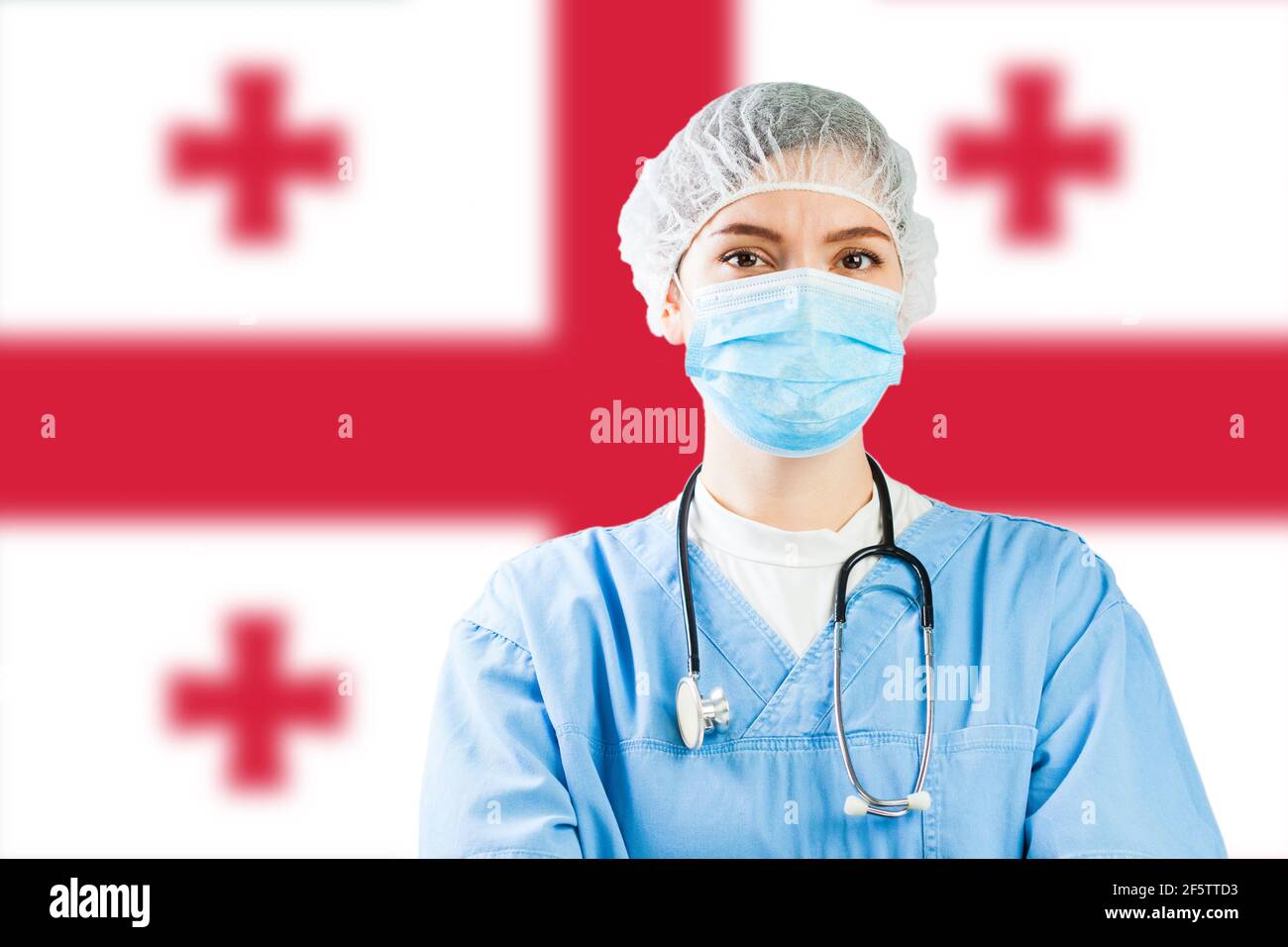 Portrait of a female doctor with flag of Georgia in background, COVID-19 virus disease crisis, Coronavirus global worldwide pandemic, social distancin Stock Photo