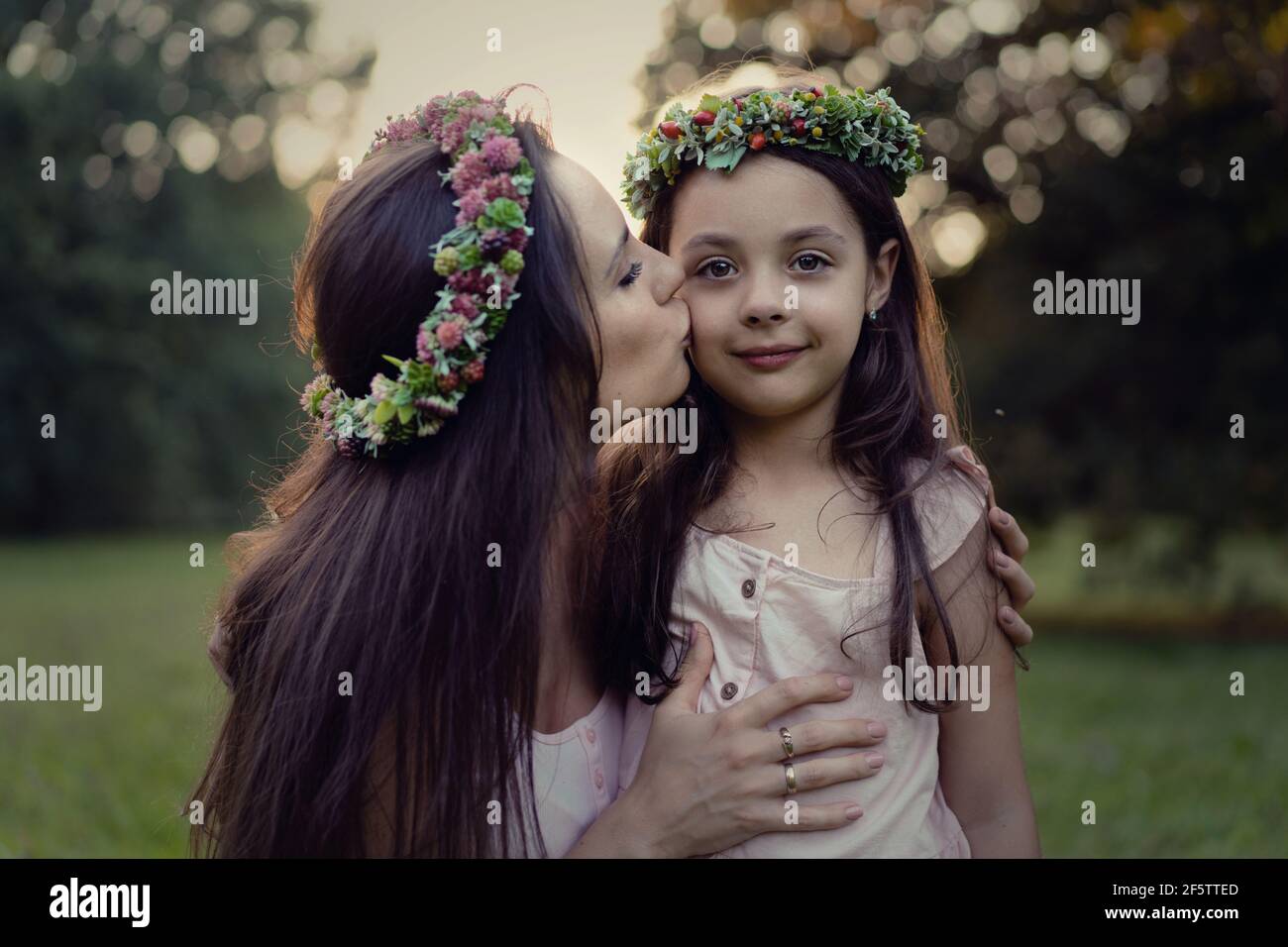 Portrait of a pretty mother kissing her beloved daughter - outdoor concept Stock Photo