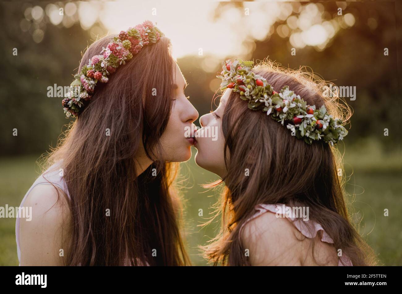 Portrait of a pretty mother kissing her beloved daughter - outdoor concept Stock Photo