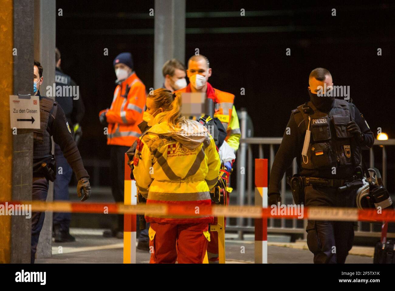 Niedernhausen, Germany. 27th Mar, 2021. Police officers are on duty while rescue workers take away a person. A drunk man fired a shot with his pistol on a regional train in Hesse, triggering a major police operation. Members of the federal and state police as well as special units of the Hessian police were able to arrest the man on the train. Credit: Michael Ehresmann/Wiesbaden112.de/dpa/Alamy Live News Stock Photo