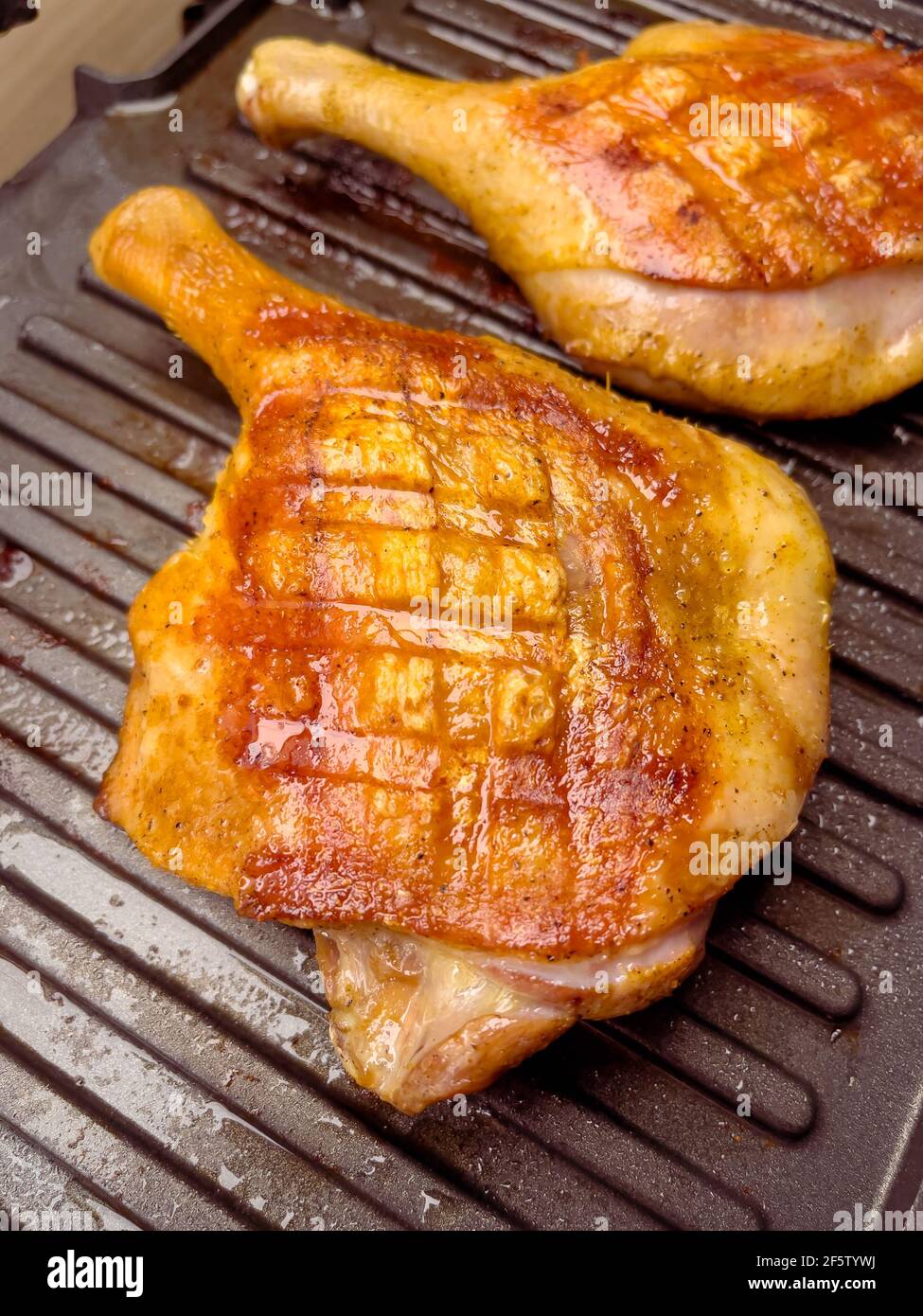 Homemade grilled duck thighs. Preparing duck meat on electric grill