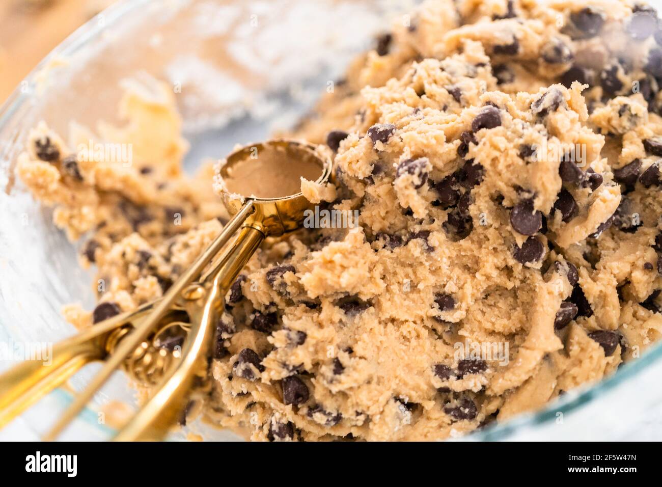 Homemade cookie dough with chocolate chips in a glass mixing bowl Stock ...