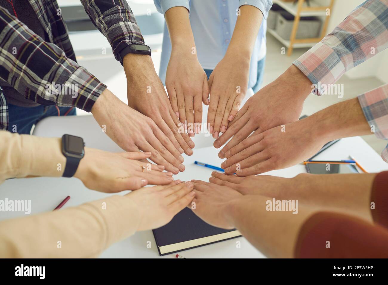 Group of school or college students join hands showing their unity and determination Stock Photo