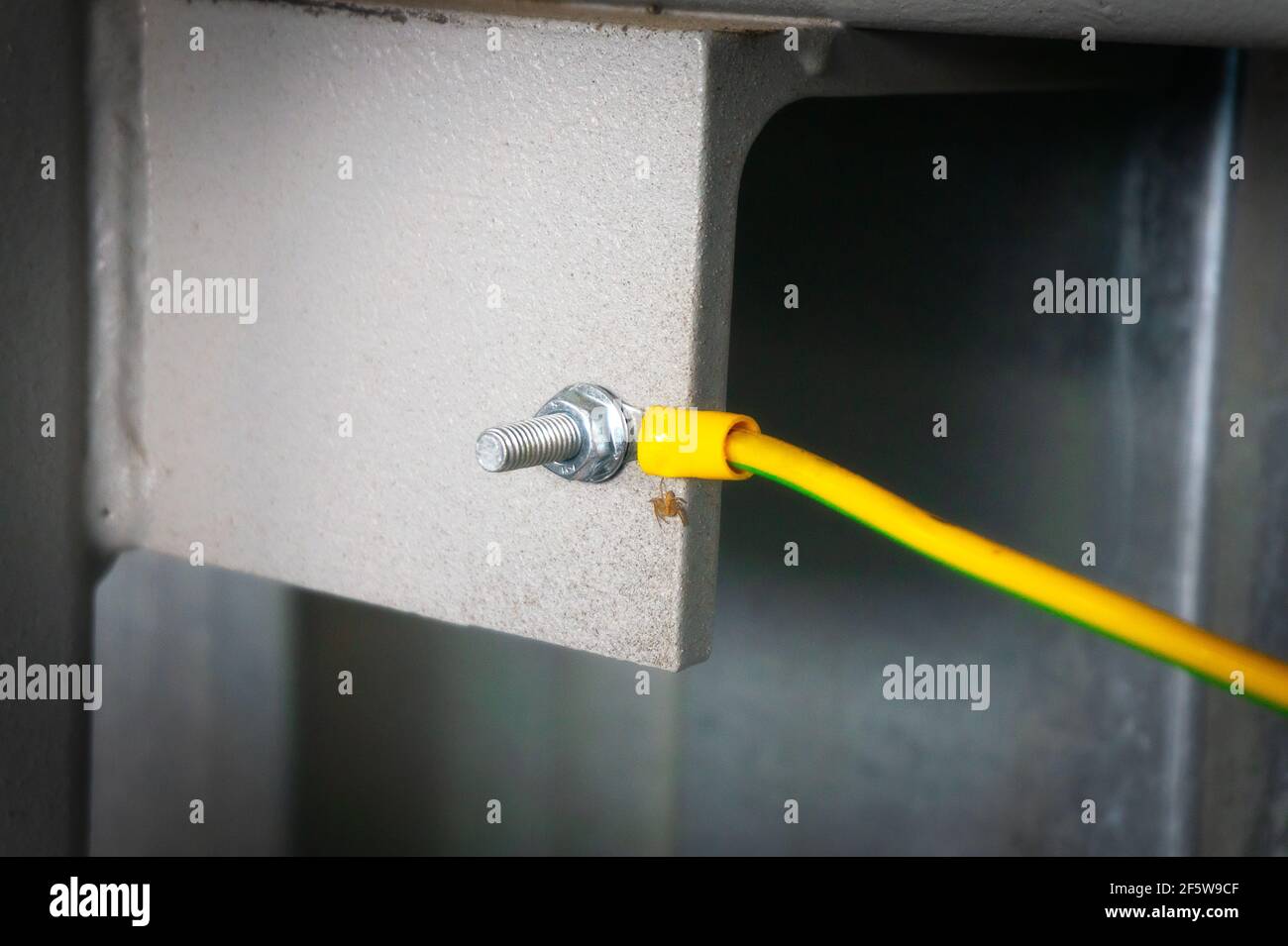 The yellow ground wire is screwed with a bolt and nut to the metal