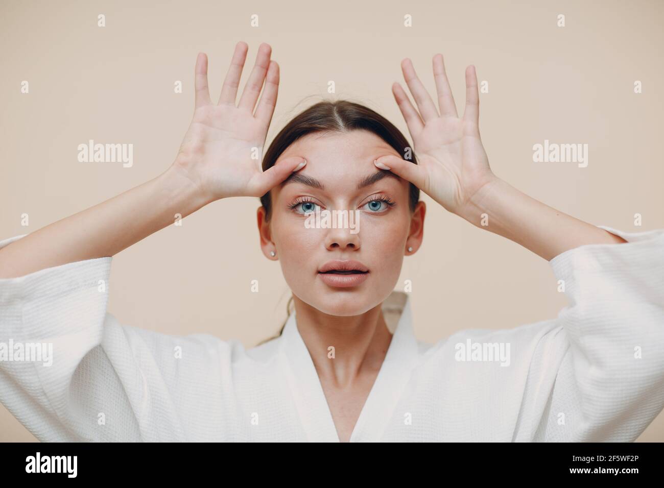 Young woman doing face building facial gymnastics self massage and