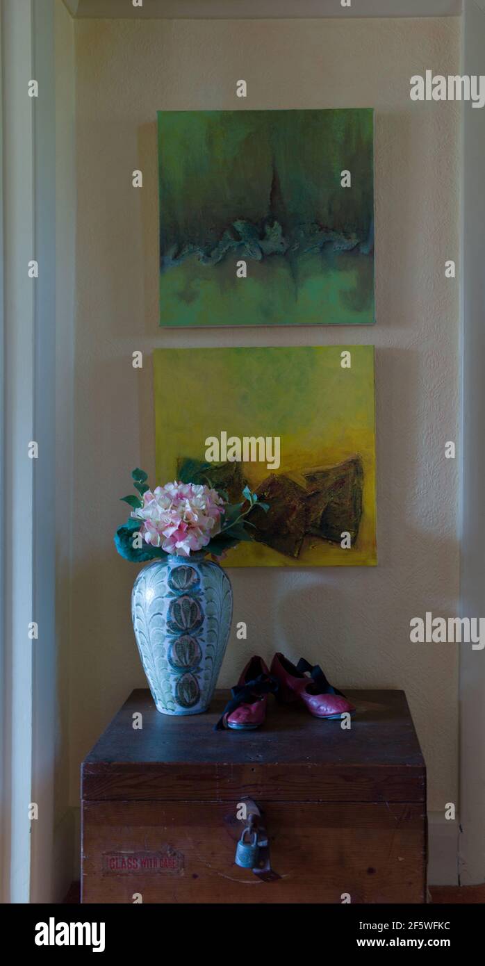 A wooden box with vase of artificial flowers and 2 paintings Stock Photo