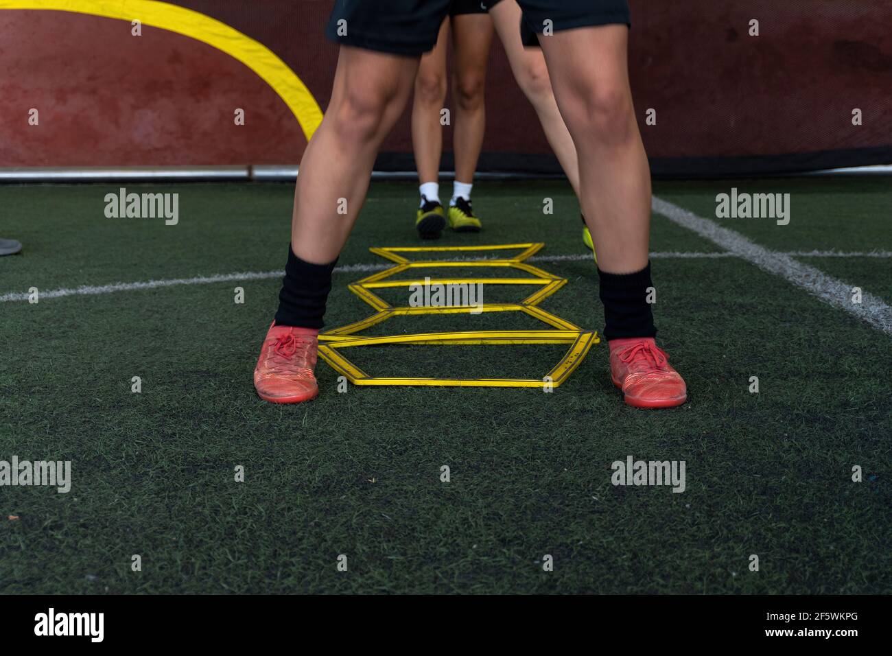 The football players on a hexagonal speed and agility training ladder