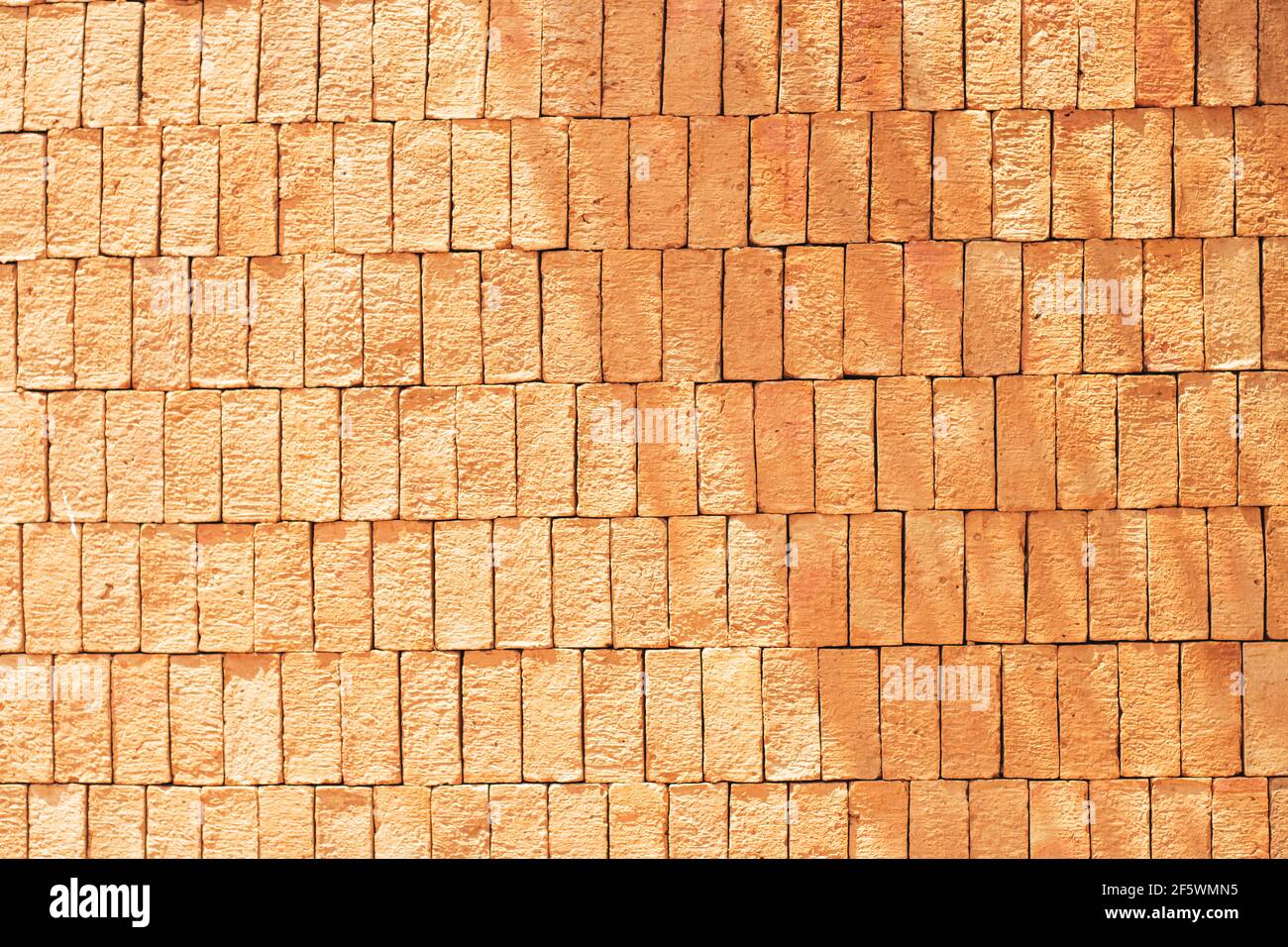 Rectangular orange bricks random pattern wall facade texture material in architecture exterior and interior. Stock Photo