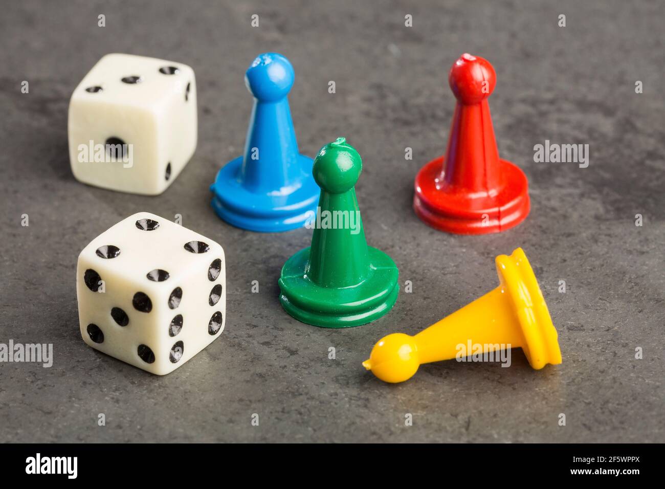 Game pieces with dices on slate Stock Photo