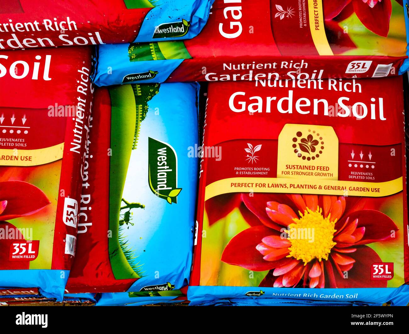A stack of bags of Westland nutrient rich Garden Soil in a garden