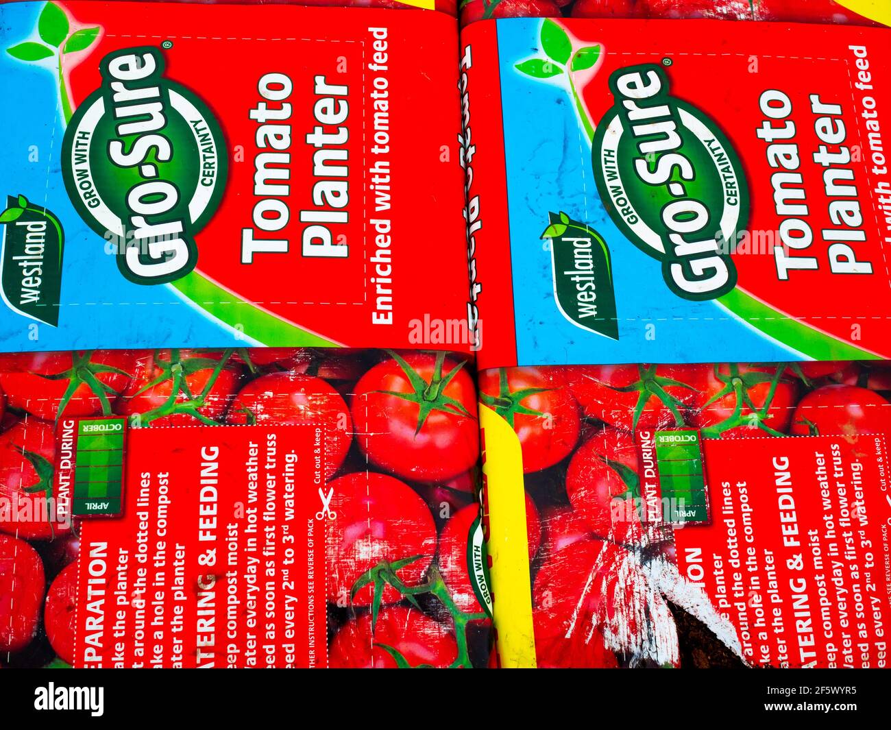 A stack of  large Gro Sure Tomato Planter Packs in a garden centre used for growing tomato plants Stock Photo