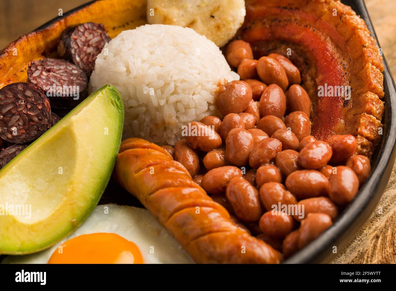 Bandeja paisa, typical dish at the Antioqueña region of Colombia. It consists of chicharrón (fried pork belly), black pudding, sausage, arepa, beans, Stock Photo