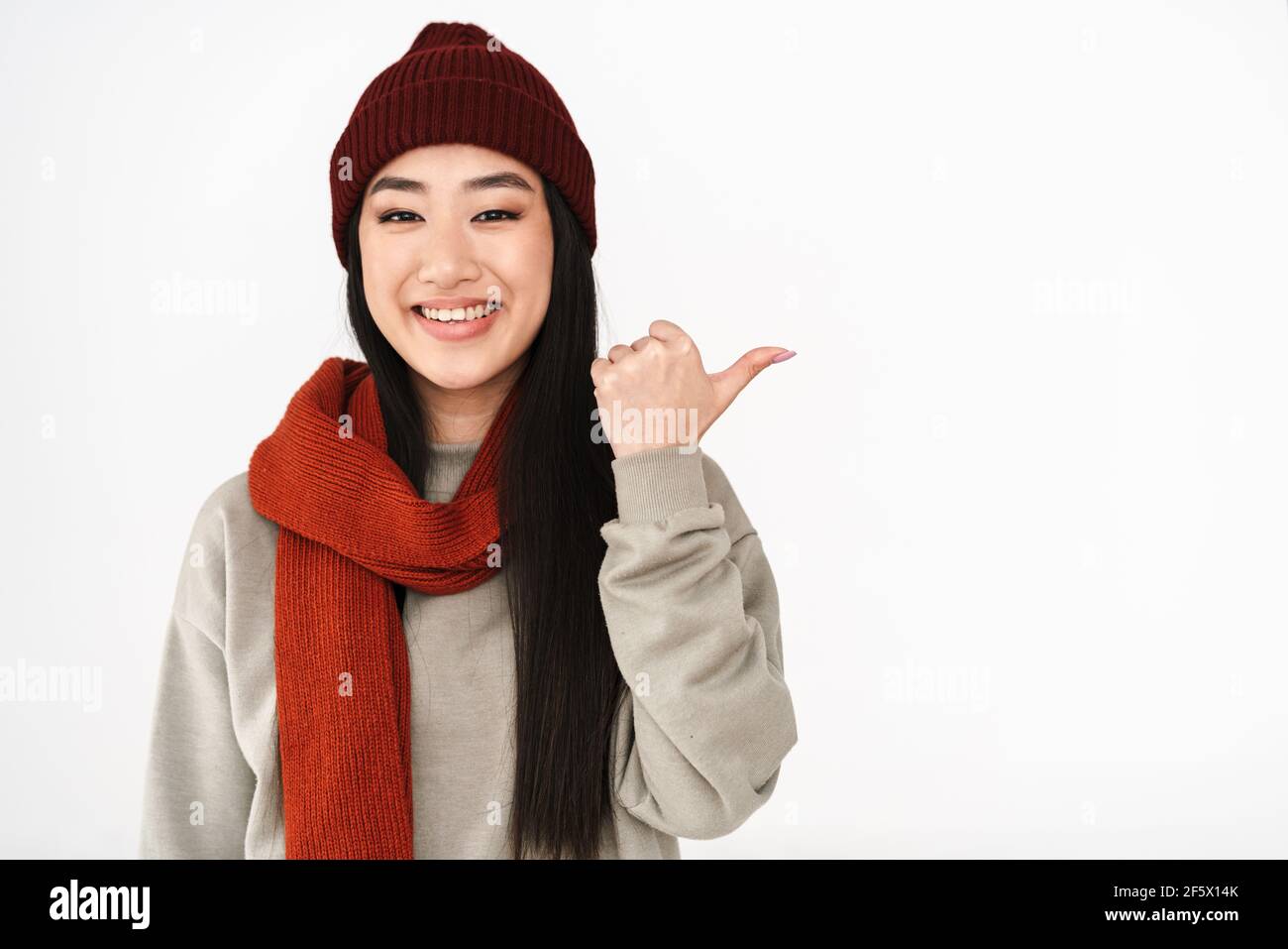 Asian happy nice girl smiling and pointing finger aside isolated over ...
