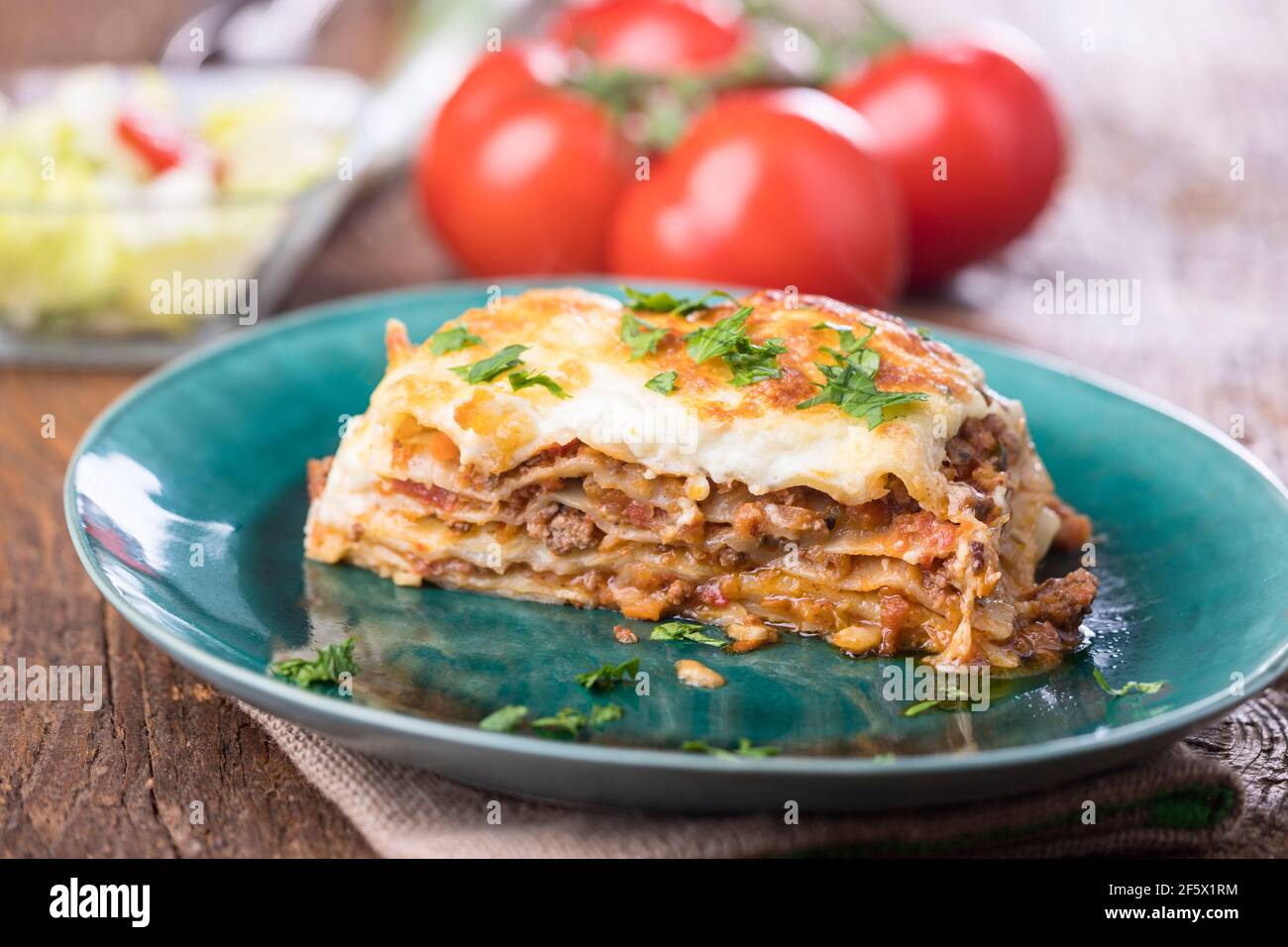 portion of lasagna on a green plate Stock Photo Alamy