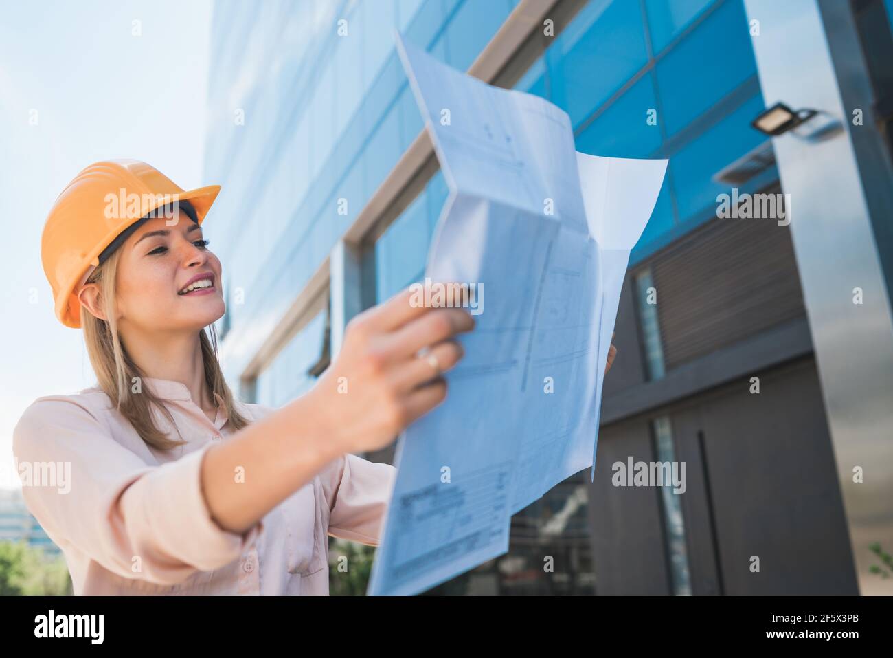 Professional architect holding blueprints outdoors Stock Photo Alamy