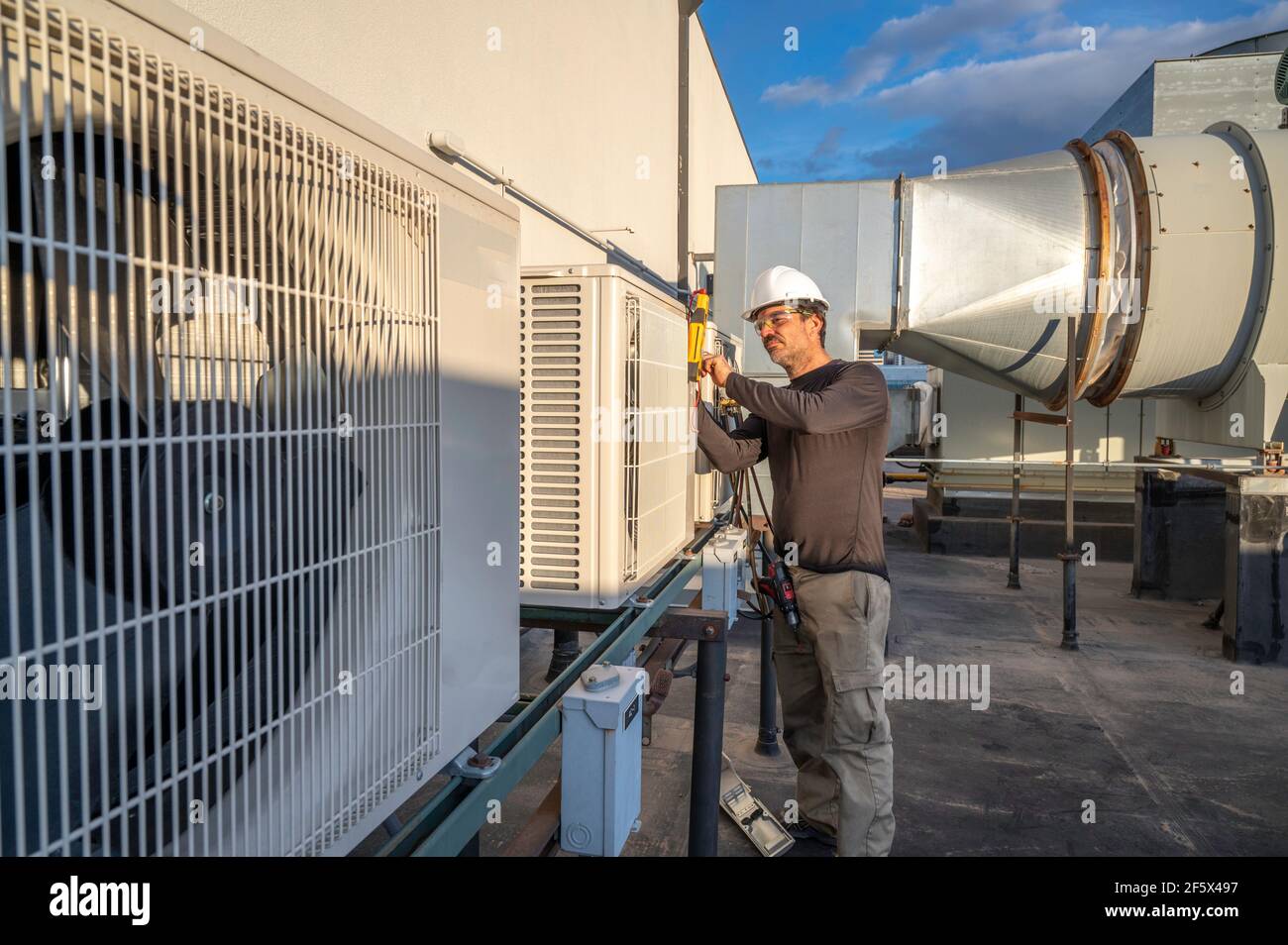HVAC technician servicing commercial air conditioning equipment on