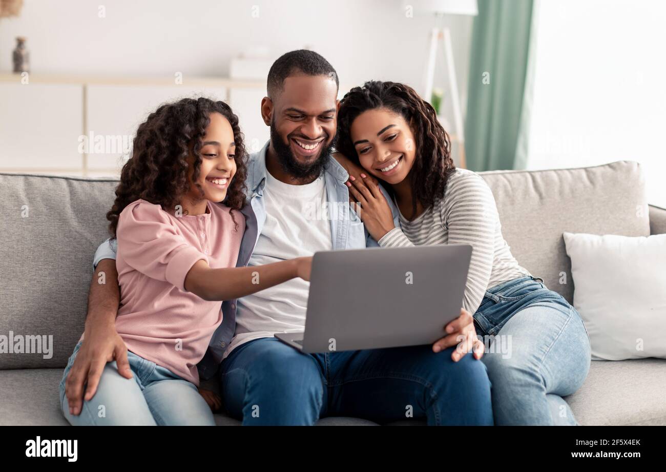 Happy african american family using laptop in living room Stock Photo ...