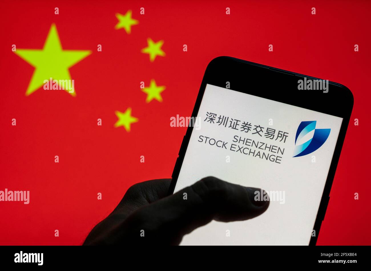 China. 28th Mar, 2021. In this photo illustration the Shenzhen stock trading exchange index logo seen on an Android mobile device with People's Republic of China flag in the background. (Photo by Budrul Chukrut/SOPA Images/Sipa USA) Credit: Sipa USA/Alamy Live News Stock Photo
