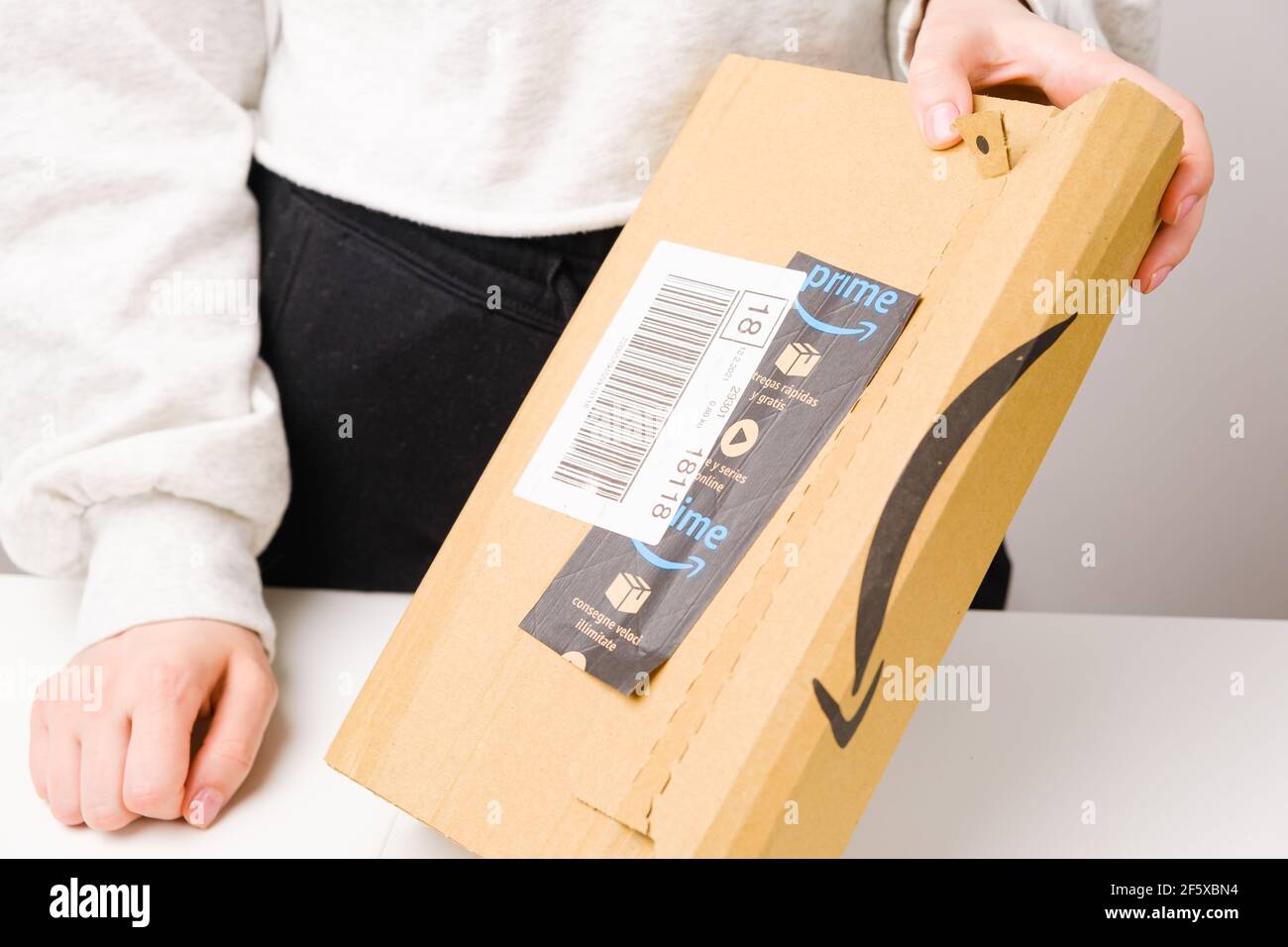 Close up woman hands opening a parcel from Amazon prime, March 2021, Prague, Czech Republic Stock Photo