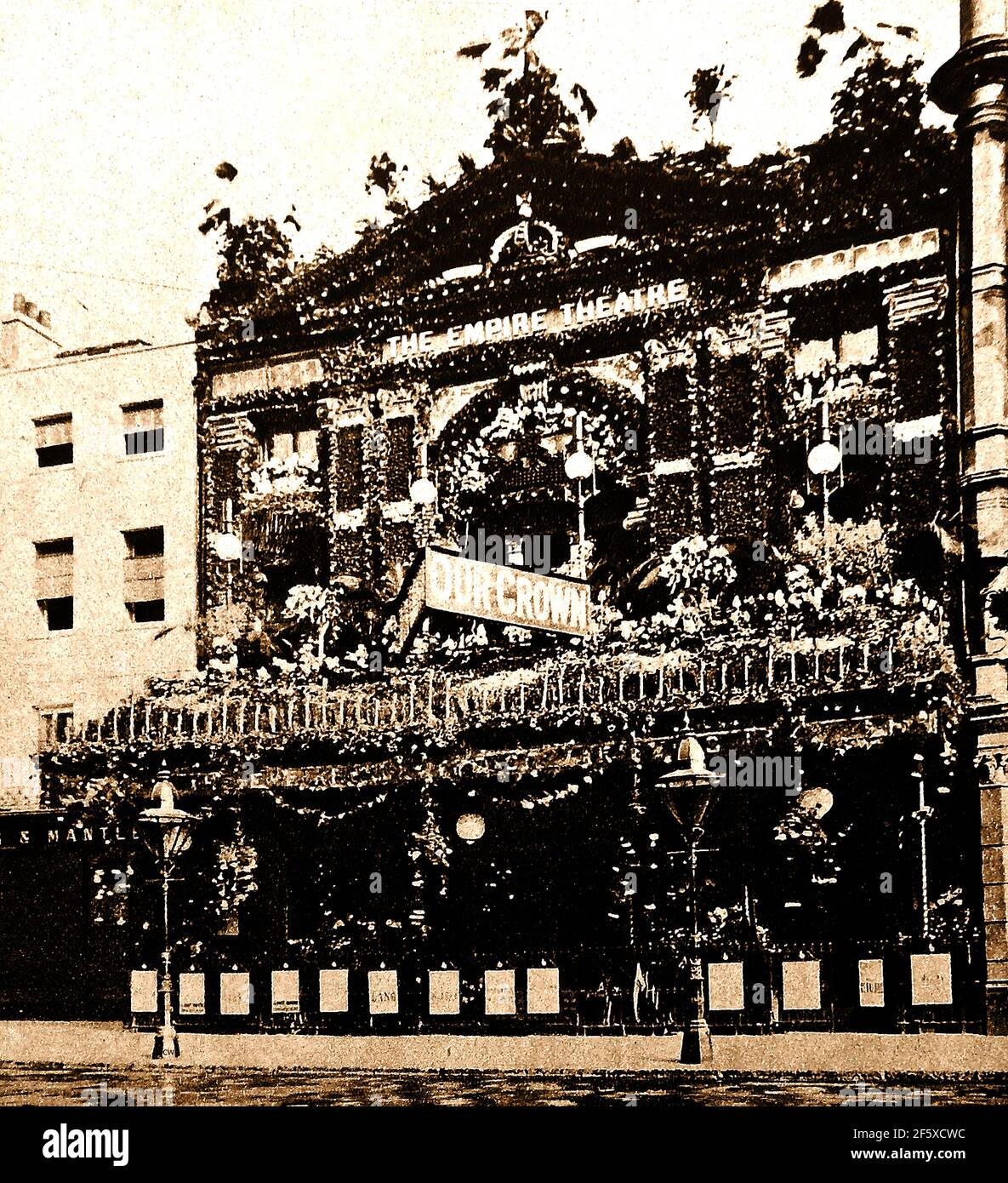Summer 1902. London decorates the streets for the Coronation celebration of the coronation of Edward VII and his wife Alexandra of Denmark.   Originally scheduled for 26 June of that year, the ceremony had been postponed at very short notice, because the King had been taken ill  and had to be hospitalised. This old photo shows the old Empire Theatre. Stock Photo