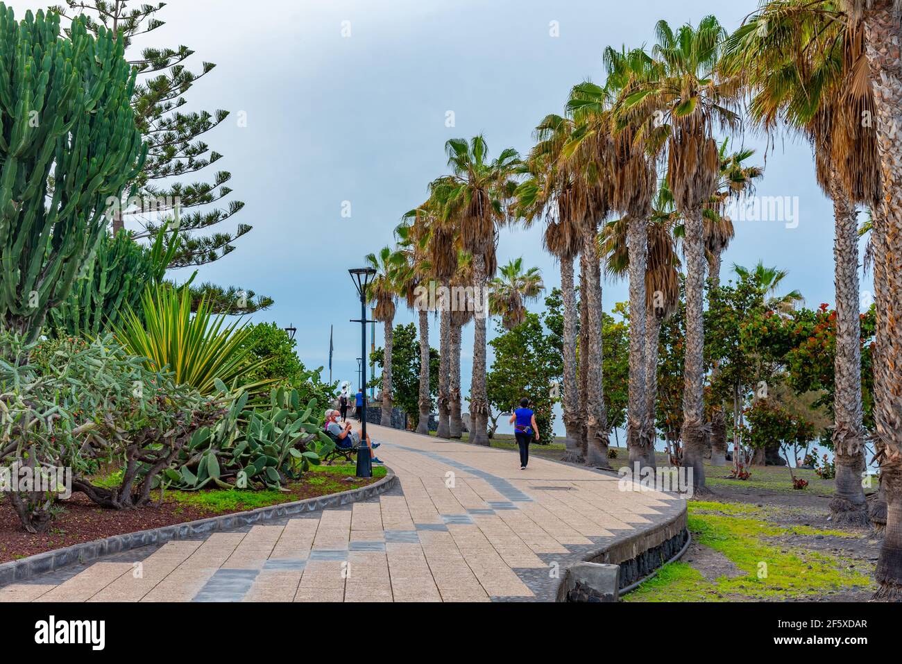 Puerto de la Cruz, Spain, Janury 3, 2021: People passing seaside promenade at Puerto de la Cruz, Tenerife, Canary islands, Spain. Stock Photo